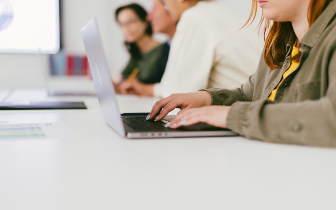 Detail of the hand of a young office worker typing an email on the laptop